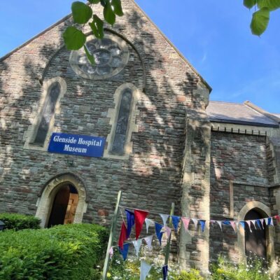 Glenside Hospital Museum in Fishponds, exterior picture shown with party bunting in the sun, during free walking tour. Museum of mental health care exploring the history of Glenside Hospital in Fishponds, Bristol.