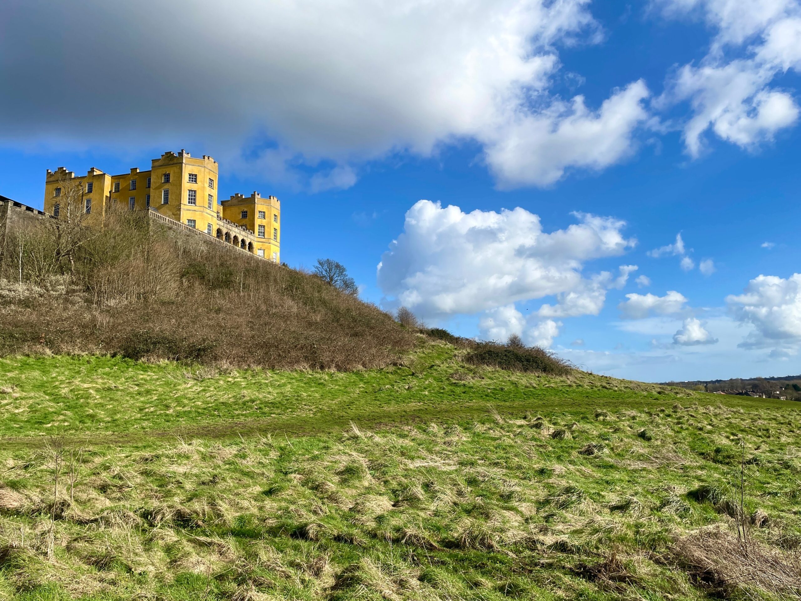 yellow building Dower House on a grassy hill on the side of M32 motorway in Bristol